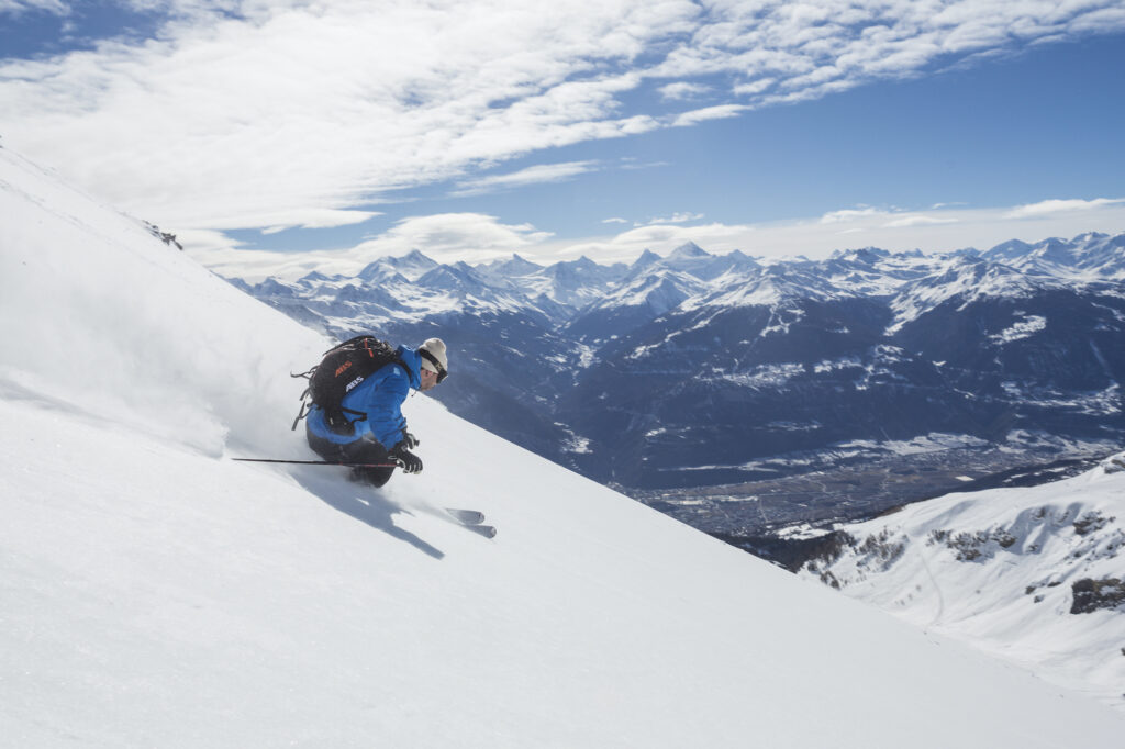 A skier skiing down Crans-Montana Ski resort in Switzerland