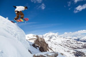 Snowboarding catching air on mountain