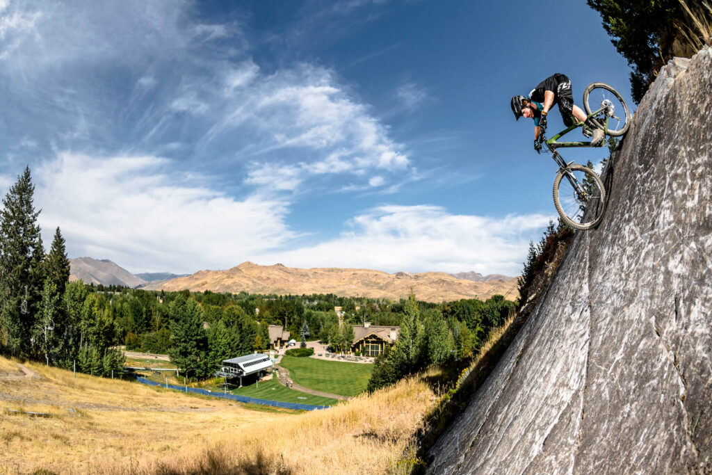 Biking down a steep rock face at Sun Valley Resort on a sunny summer day