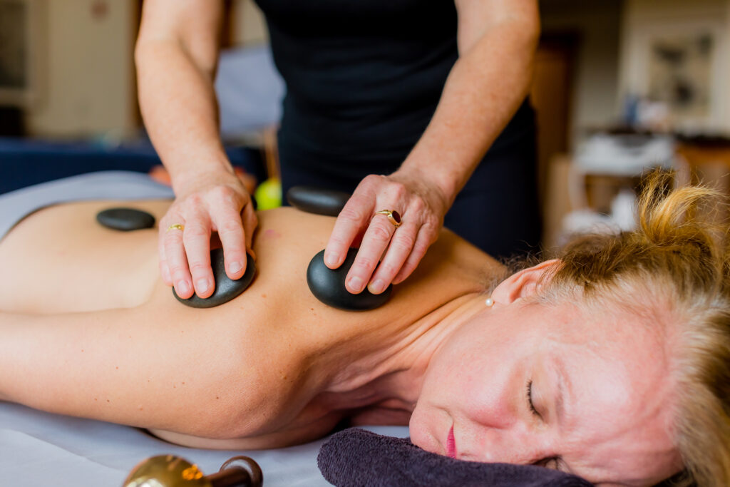 Woman getting stone massage in spa treatment room