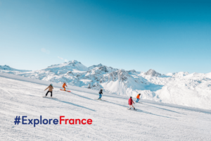 Skiers skiing down groomed slopes in Tignes, France on a sunny day
