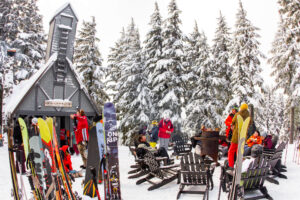 People enjoying food and drinks outside in the snow outside of cabin