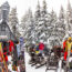 People enjoying food and drinks outside in the snow outside of cabin