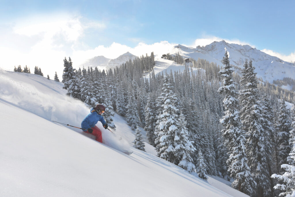 Person skiing through powder at Telluride on a sunny day