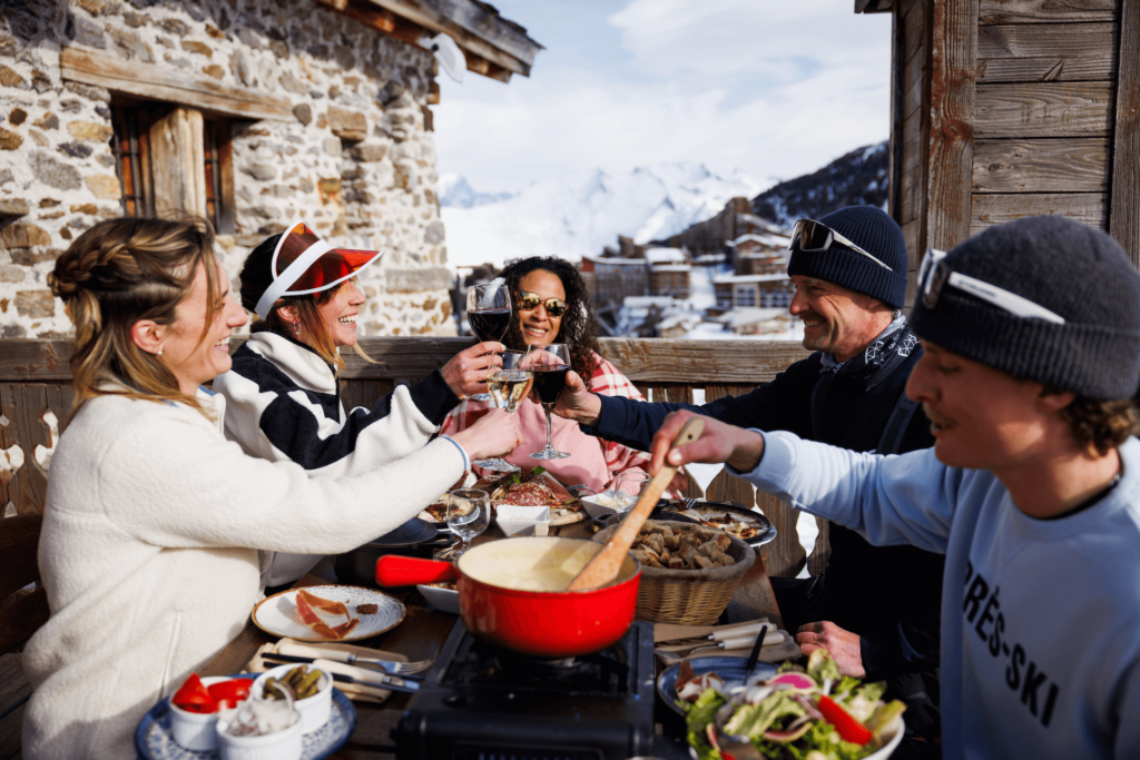 Group of friends toasting glasses and enjoying food on patio