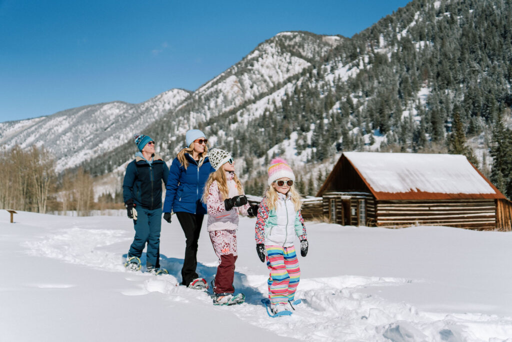 Family snowshoeing on a sunny day in Aspen