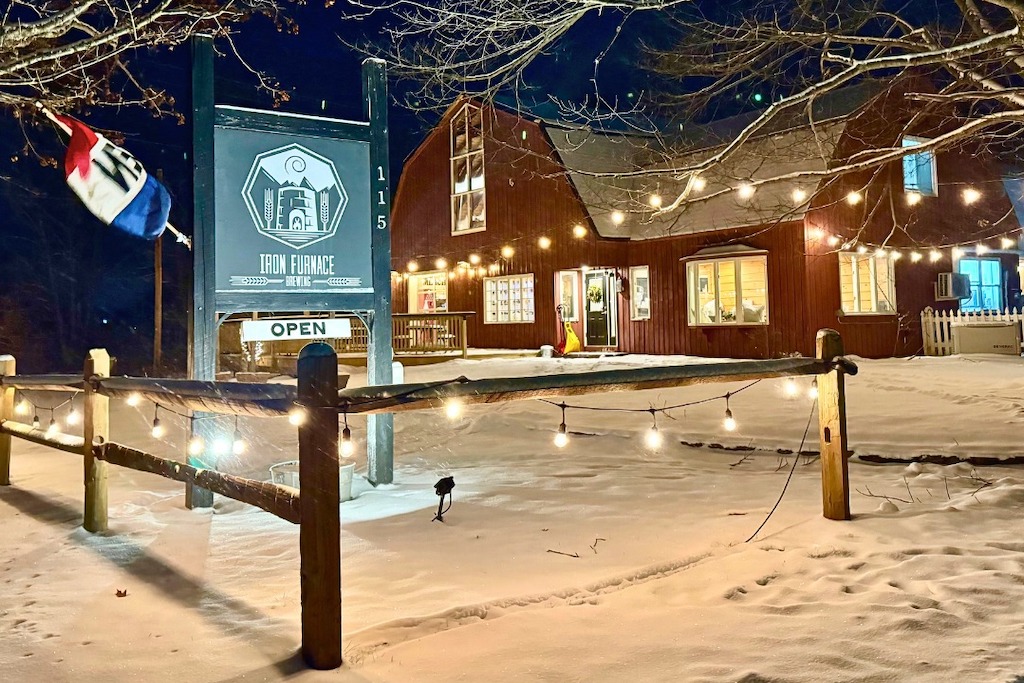 Iron Furnace Brewing lit up at night and surrounded by snow