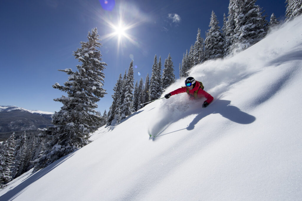 Bluebird powder day in Aspen where skier rips through powder