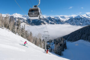 Telluride gondola just above skiers on slopes of Telluride Ski Resort