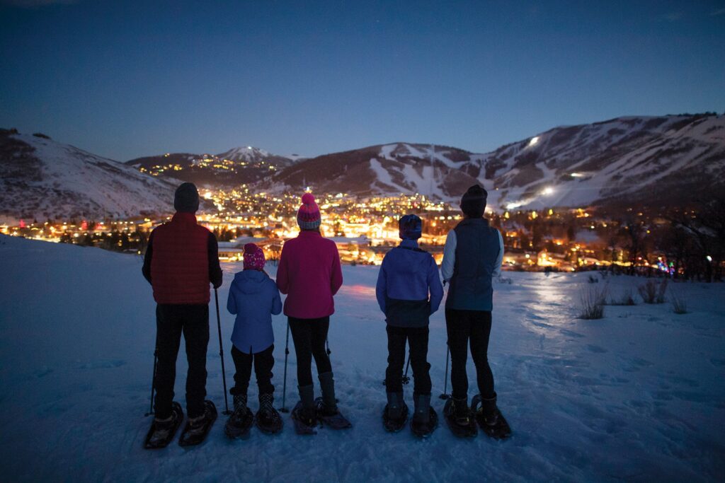 Family overlooking Park City while snowshoeing