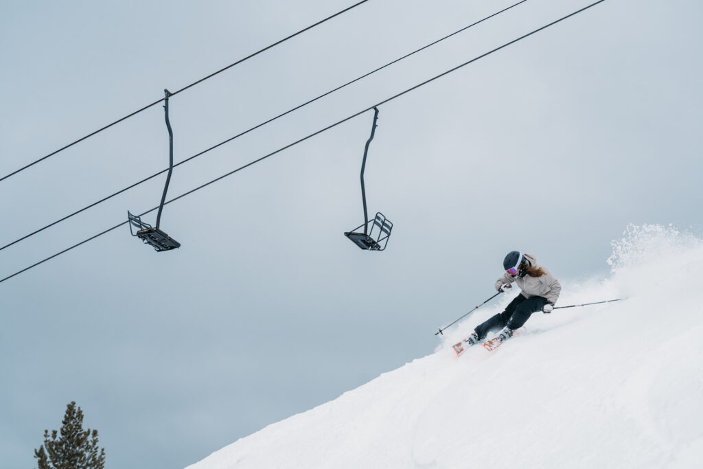 Person skiing down slopes beneath chairlift at Discovery Ski Area