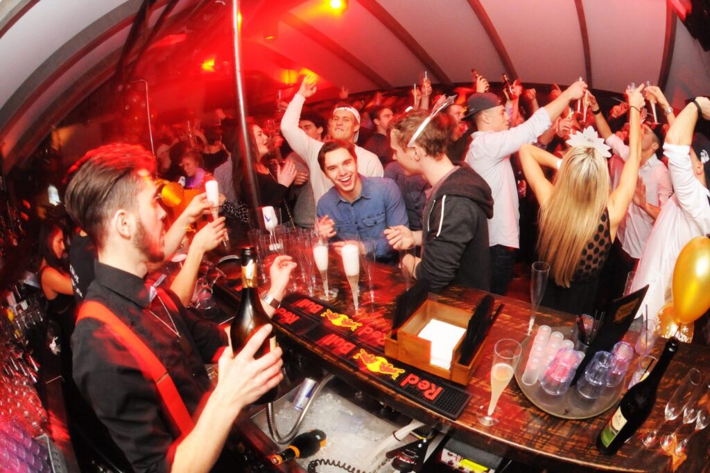 People dancing and ordering drinks at Le P’tit Caribou bar