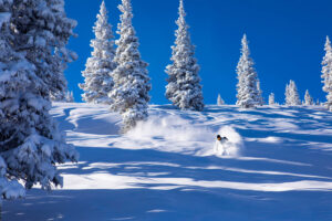 Person skiing through powder at Snowmass Resort