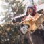 Person in winter clothing joyfully holds Christmas gifts at a festive marke