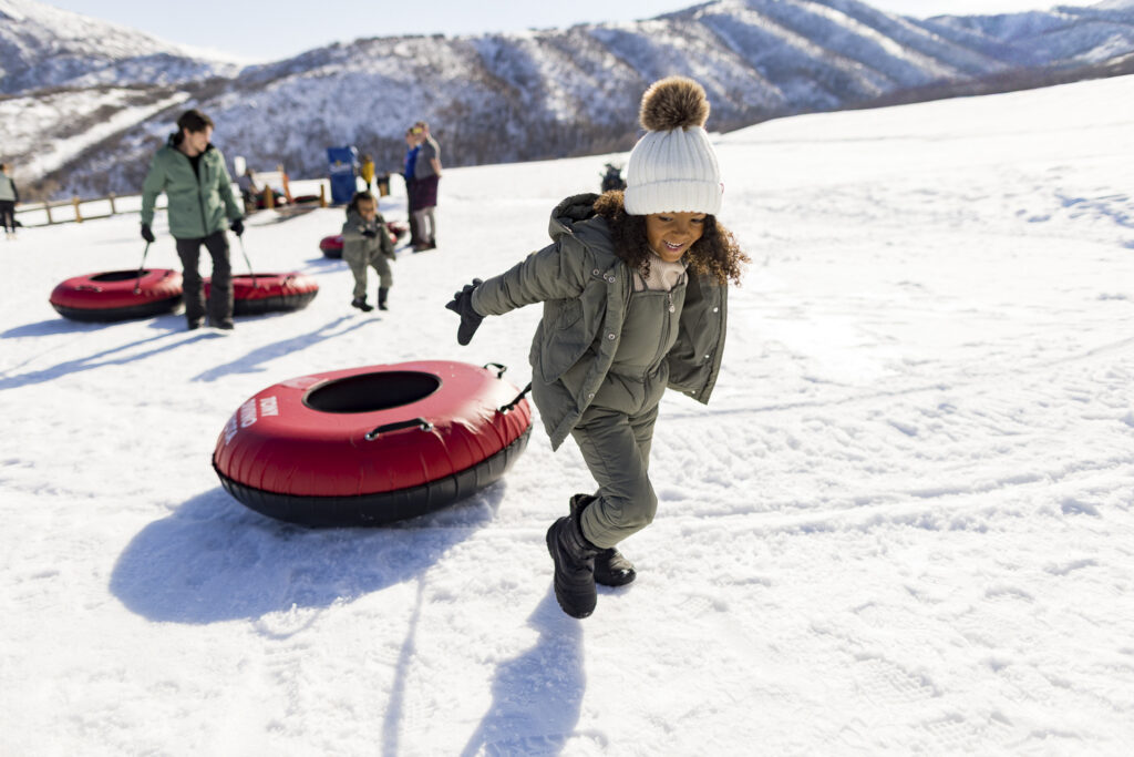 Family walking up tubing hill at Soldier Hollow in the Heber Valley