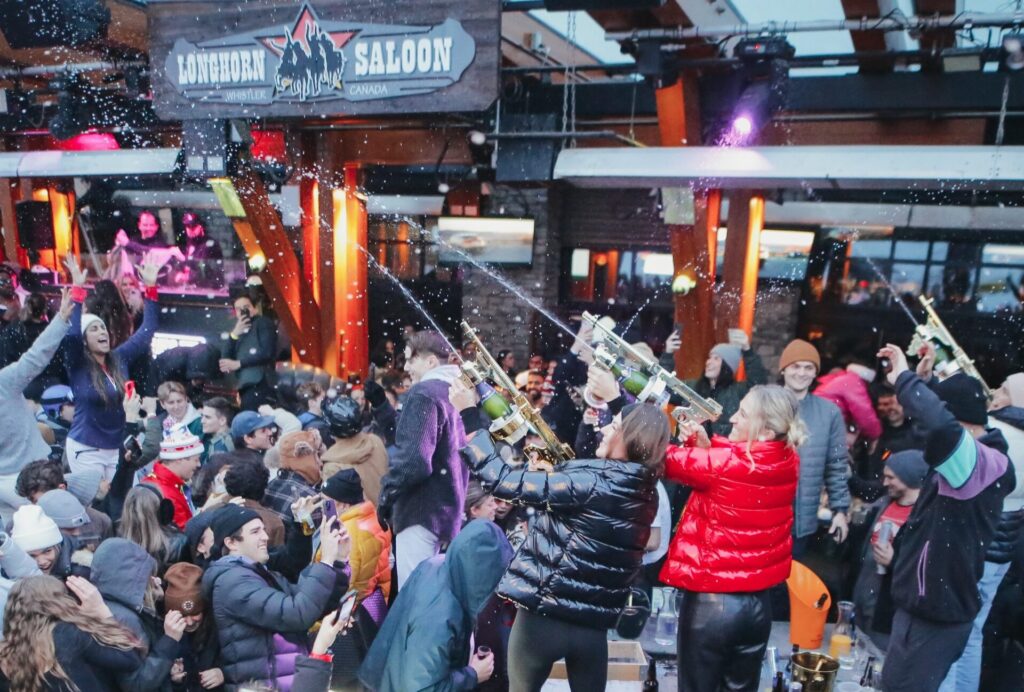People partying on the deck of Longhorn Saloon in the Village of Whistler Blackcomb