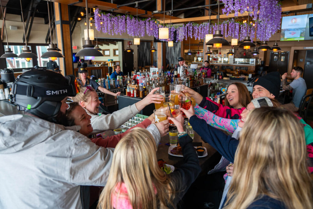 Friends toasting glasses inside of bar