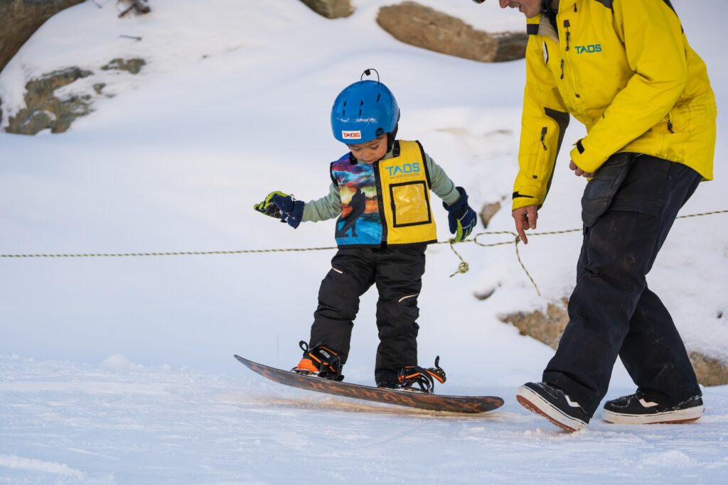 Small child learning to snowboard