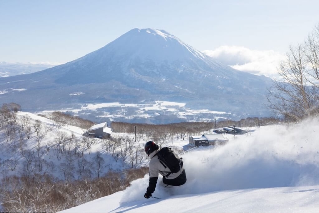 Skiing through deep powder on a bluebird day at Niseko United