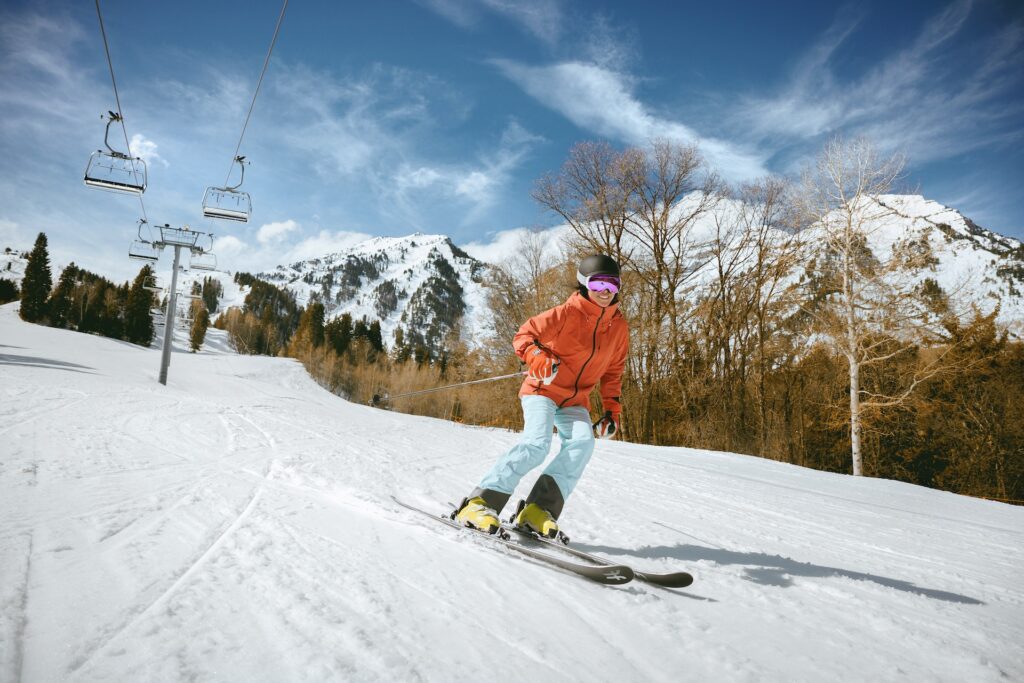 Person skiing down groomed slope on a bluebird spring day