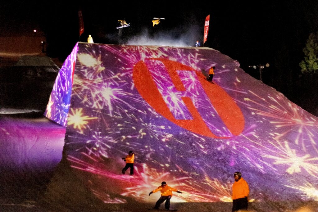 Skiers going off jump at night at Heavenly Ski Resort